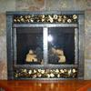 After - forged steel bar and aspen leaves with a center divider to give the impression of doors to a wood fireplace.